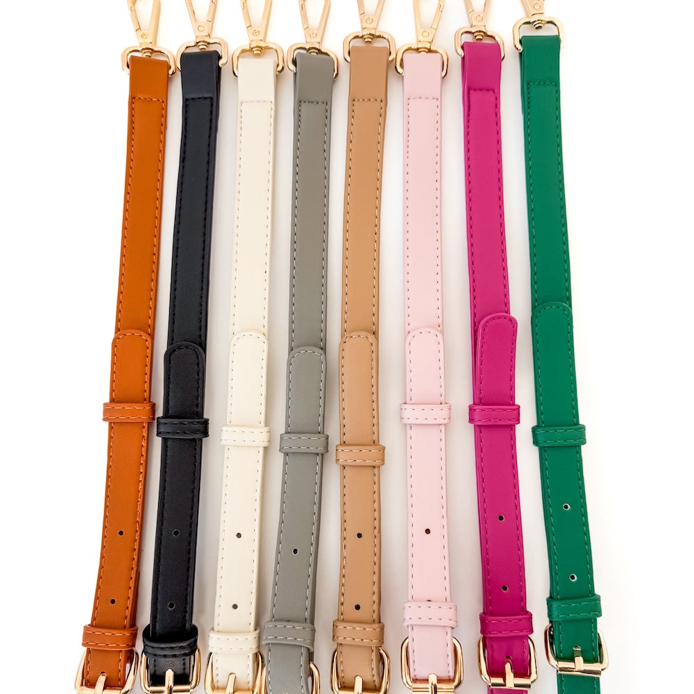 Set of colorful leather straps with gold buckles on a white background
