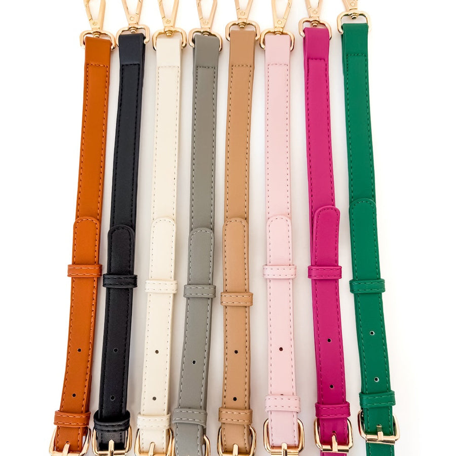 Set of colorful leather straps with gold buckles on a white background