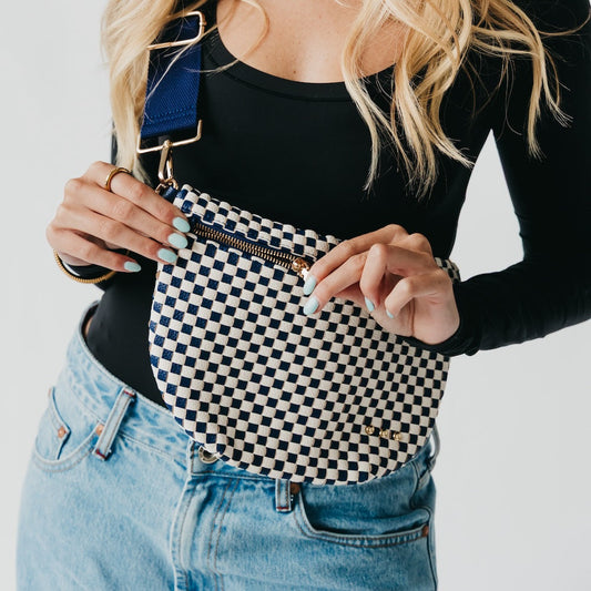 Person holding a checkered pouch with a plain background
